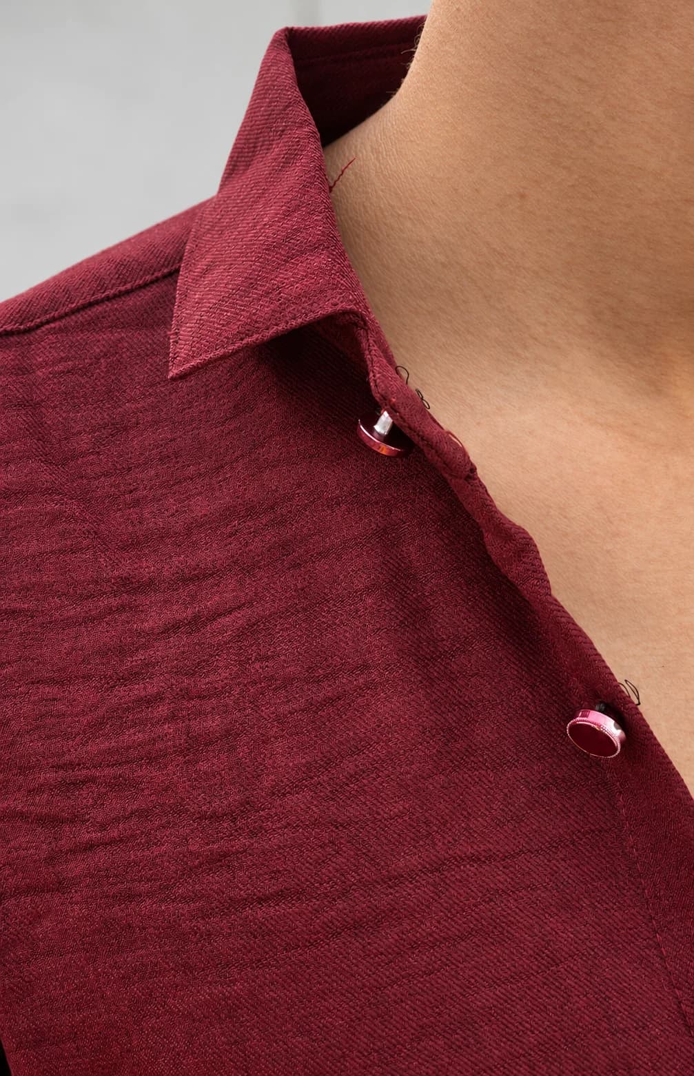 Model wearing a HUNK PLUS maroon shirt with rolled sleeves, shown from a side angle.