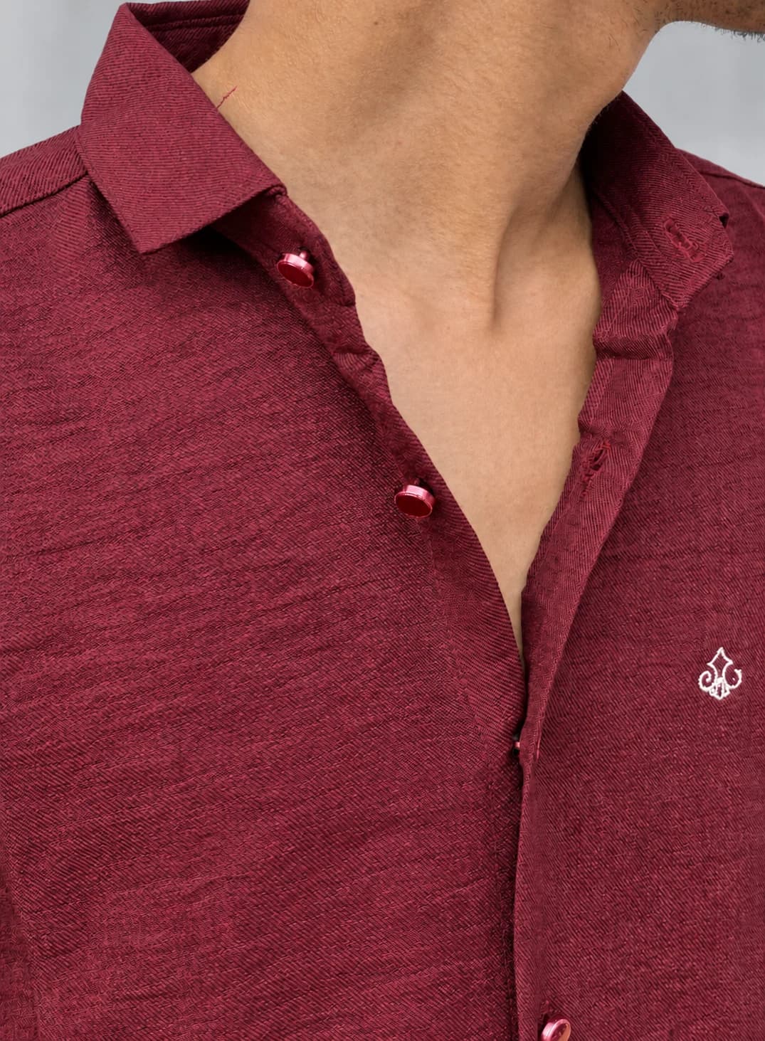 Close-up of the HUNK PLUS maroon shirt showing the open collar, matching buttons and white 