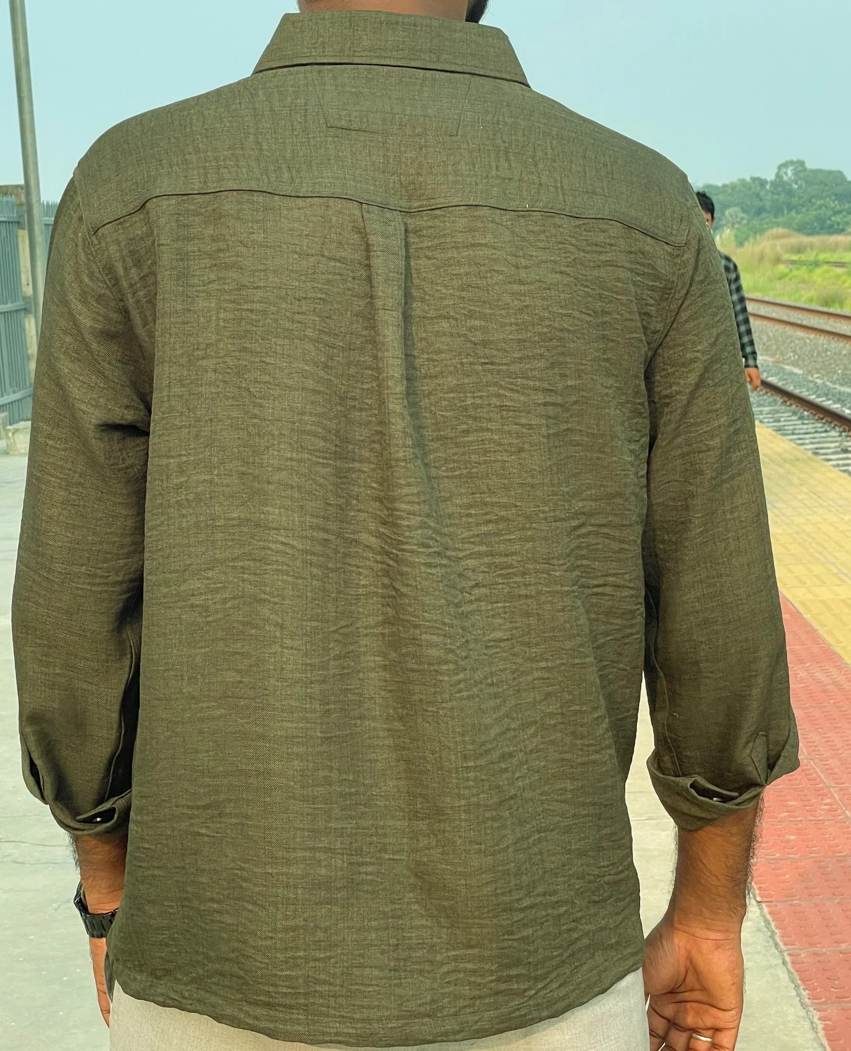 Detailed view of the olive shirt’s fabric texture and buttons